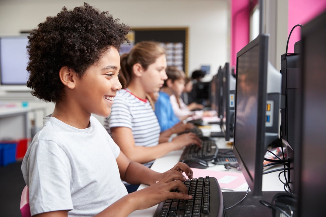 Line of High School Students Working at Screens in Computer Clas